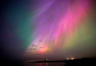 The aurora borealis, also known as the northern lights, glow on the horizon at St. Mary's Lighthouse in Whitley Bay on the North East coast, England, Friday, May 10, 2024. (Owen Humphreys/PA via AP)