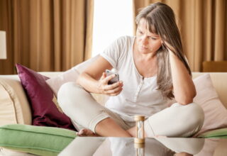Woman waiting anxiously by the phone, illustrating natural ways to manage anxiety