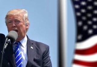Donald Trump dando un discurso, con una bandera de Estados Unidos al fondo.