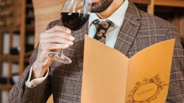 Professional wine taster swirling a glass of red wine