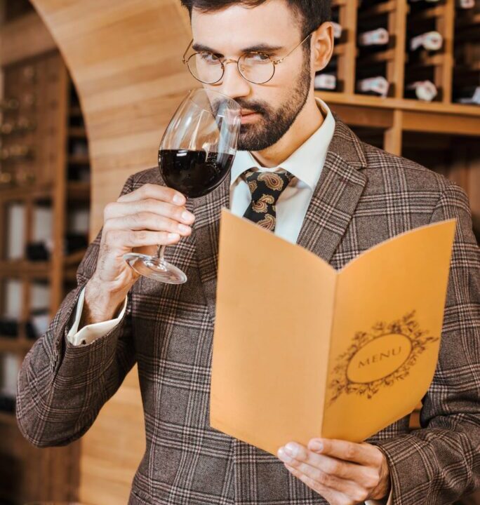 Professional wine taster swirling a glass of red wine