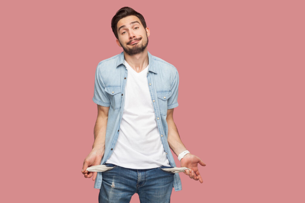 Man showing empty pockets illustrating scarcity language and the feeling of having no money.